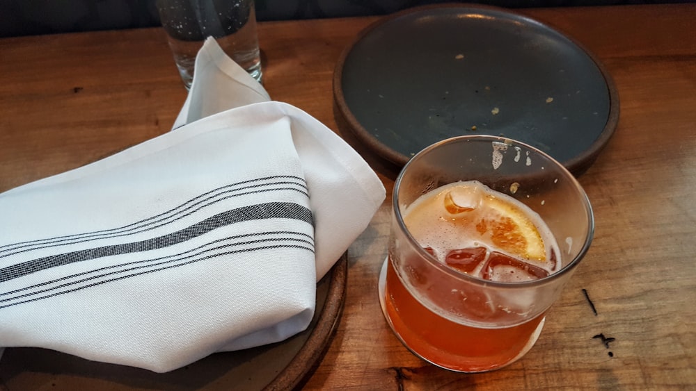 glass of drinks near table napkin