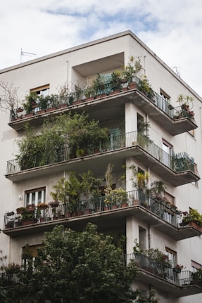 building with balconies and plants during day