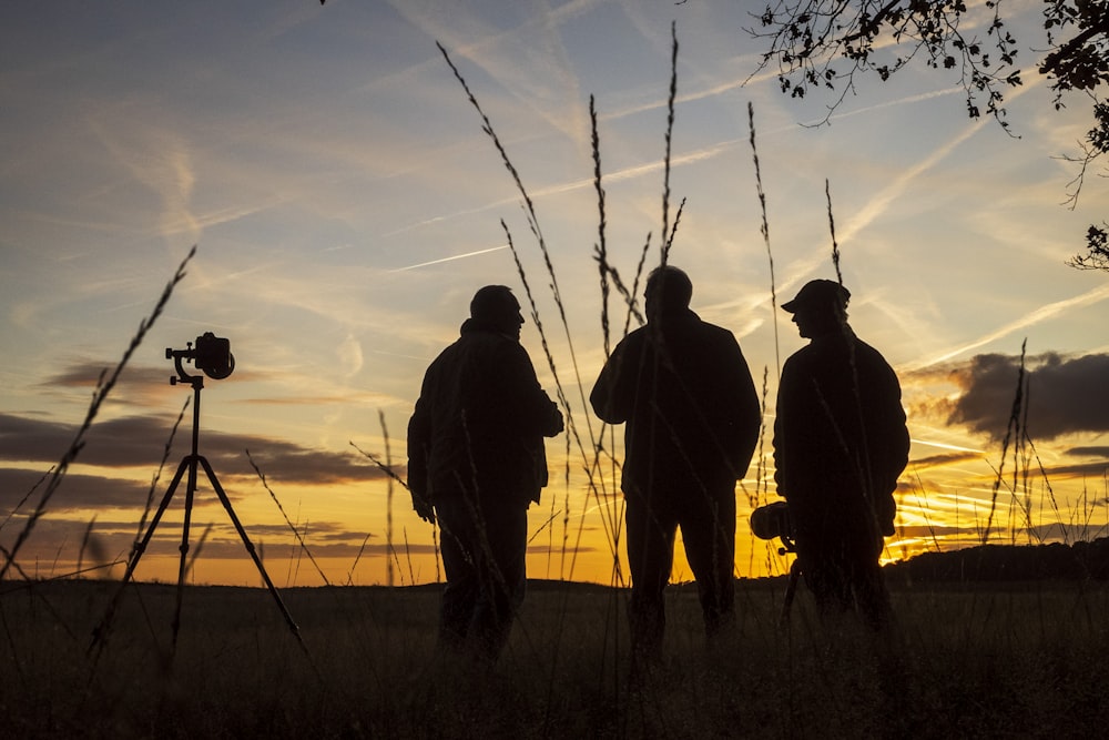 silhouette de 3 hommes debout à côté de la caméra