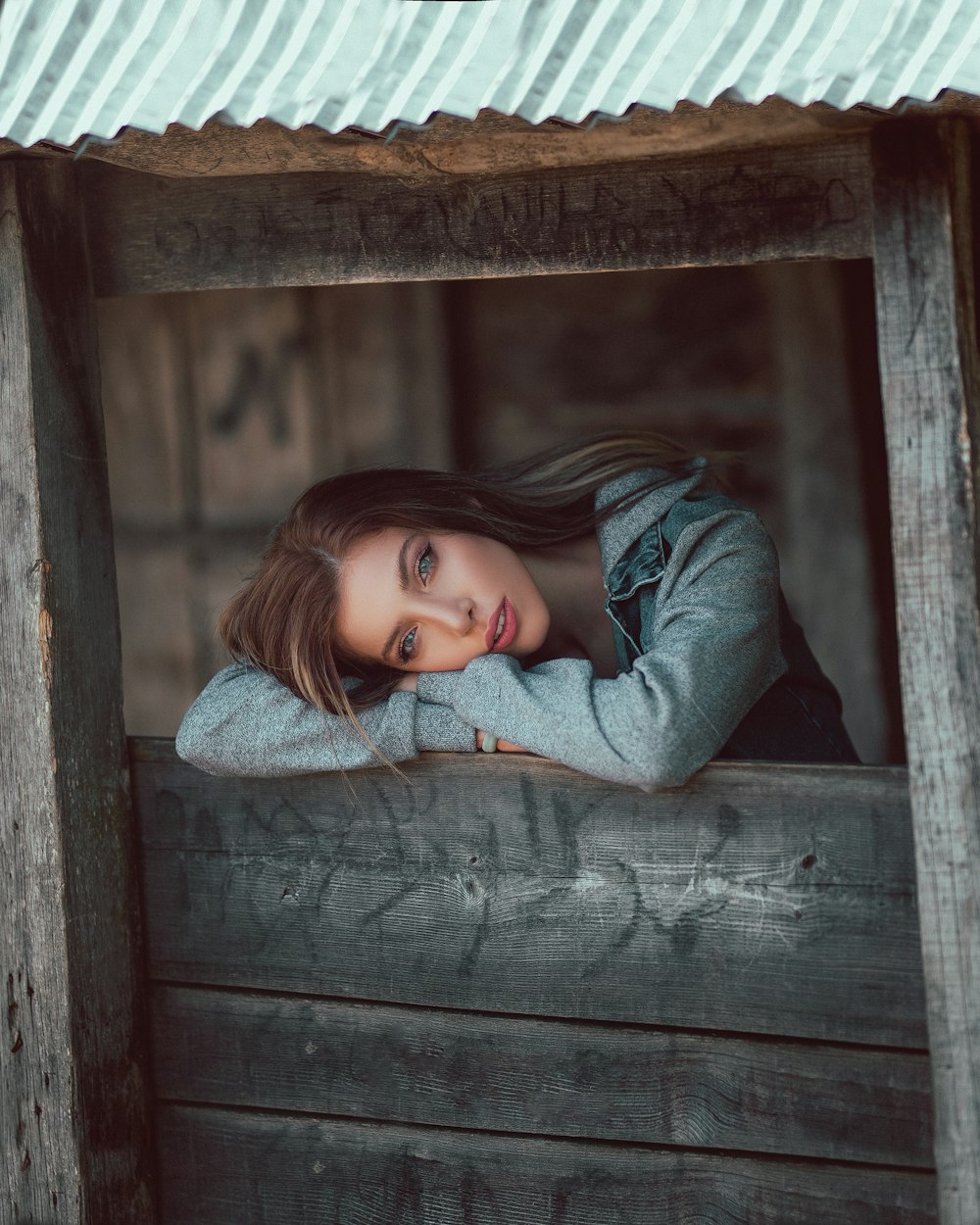 woman leaning forward on wooden window sill