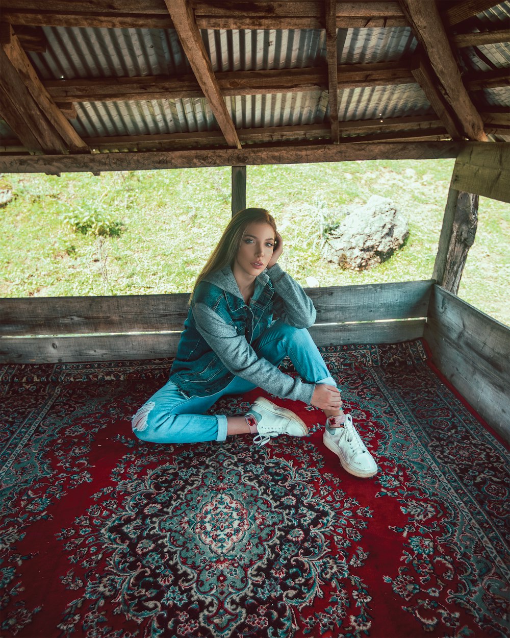 woman sitting on area rug inside house