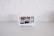 A smart display device sits on a white kitchen counter against a backdrop of white tiled walls. The screen displays various interactive options such as Find food recipes, Play videos, Manage photos, and Check news, each represented by images.