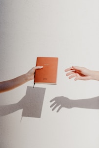 Close-up of hands holding a minimalist political-themed notebook and pen on a sober background