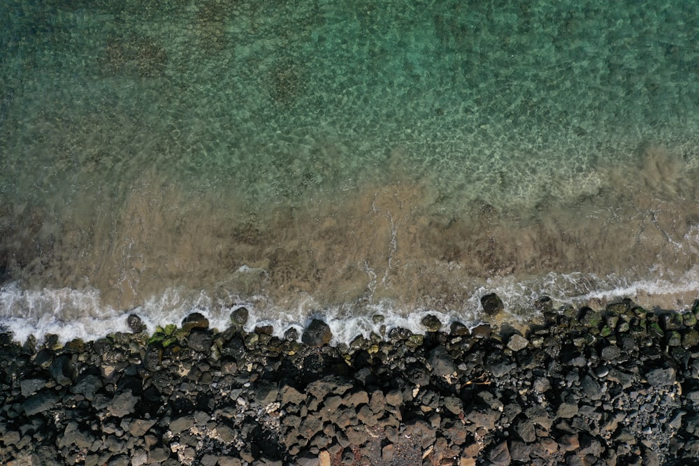 an aerial view of a rocky beach and ocean