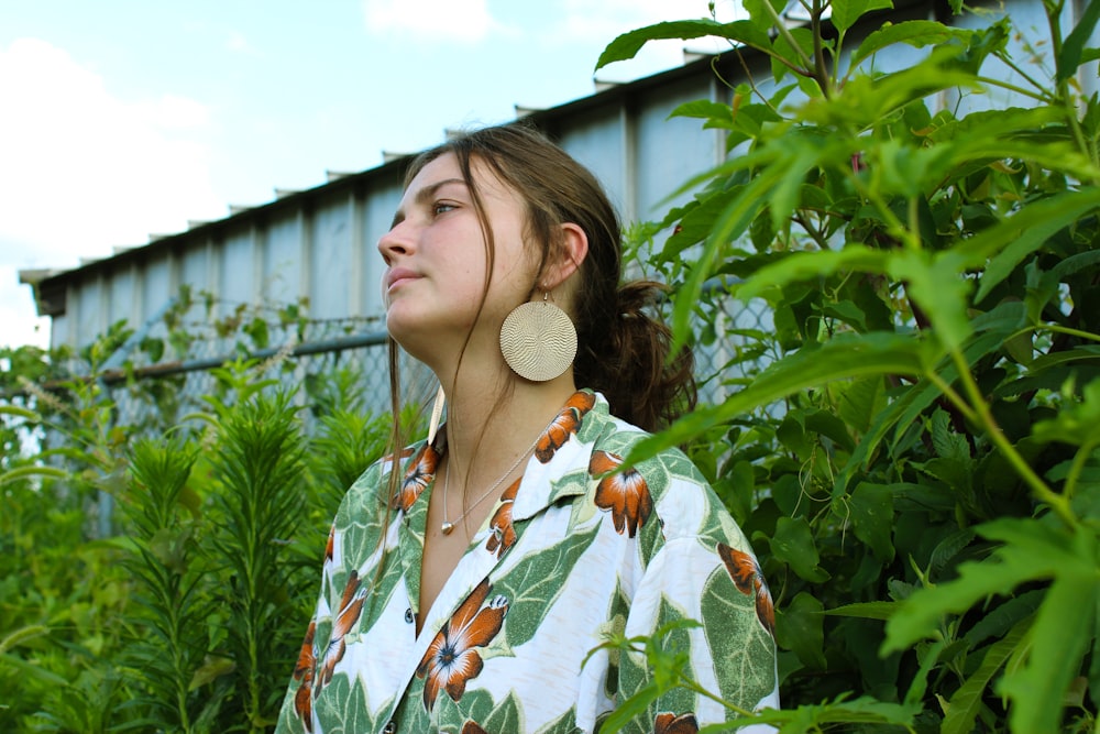 woman standing beside green-leafed plant during daytime