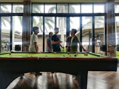 A lively game of bilardo in progress with friends enjoying their time.