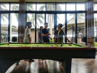 A group of friends enjoying a game of billiards in a lively setting.