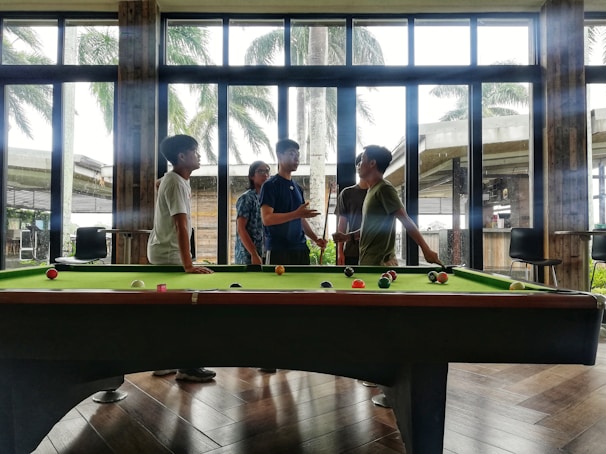 A group of friends enjoying a game of billiards in a lively setting.
