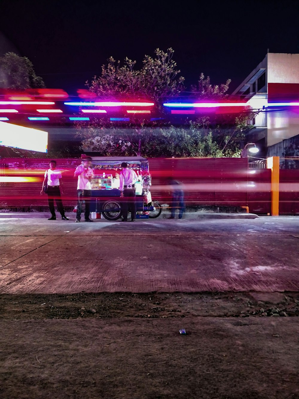 blue tricycle store stand besides concrete road time lapse photo