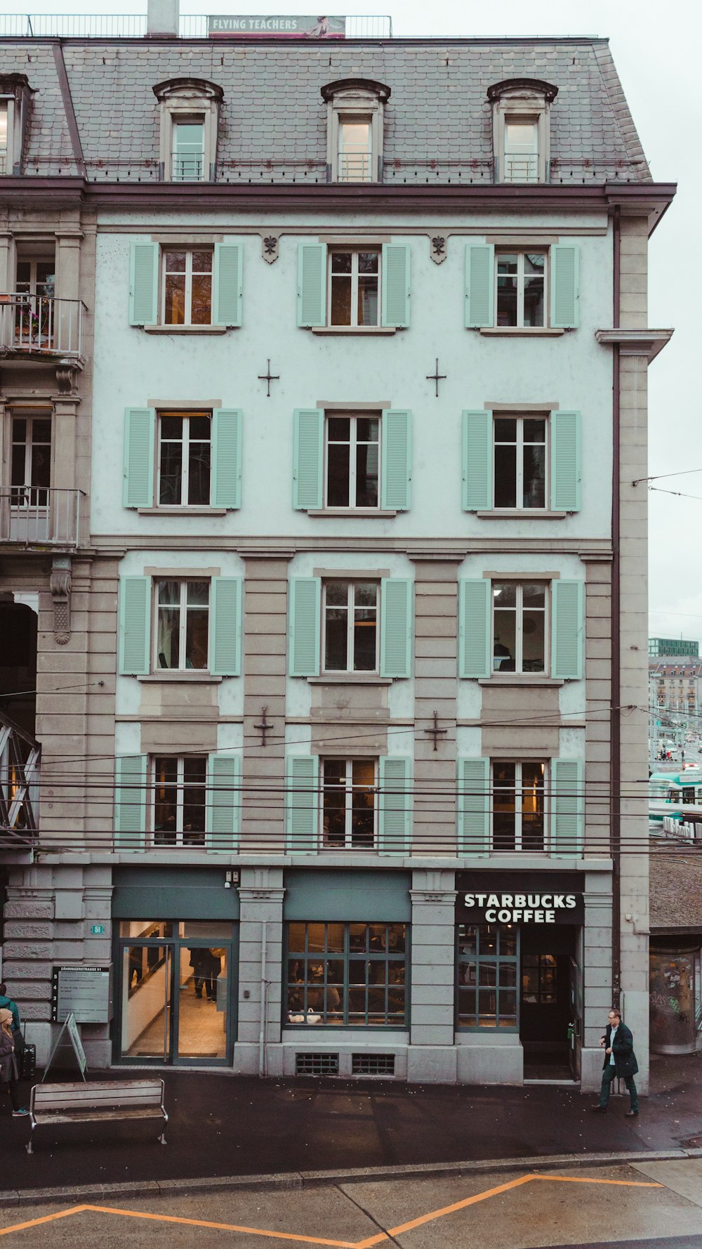 man standing beside building