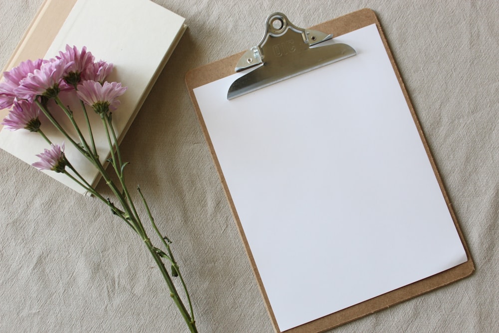 purple flower on white box and brown clipboard