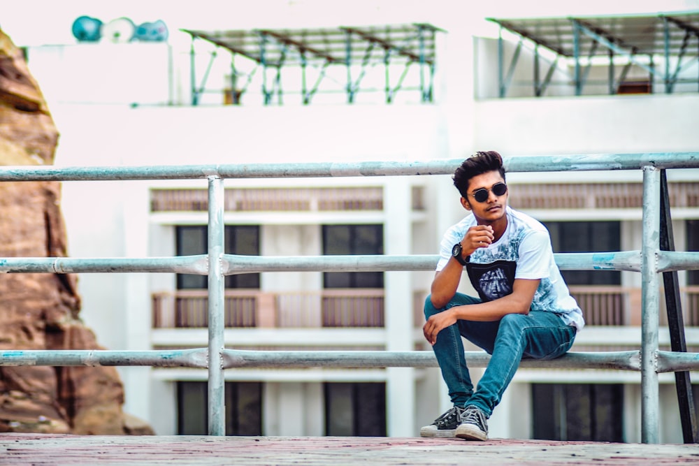 man sitting on a metal railing