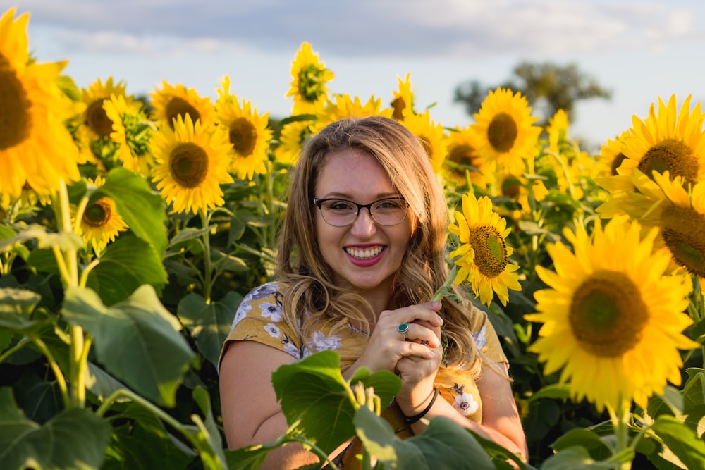 woman standing beside sunflower