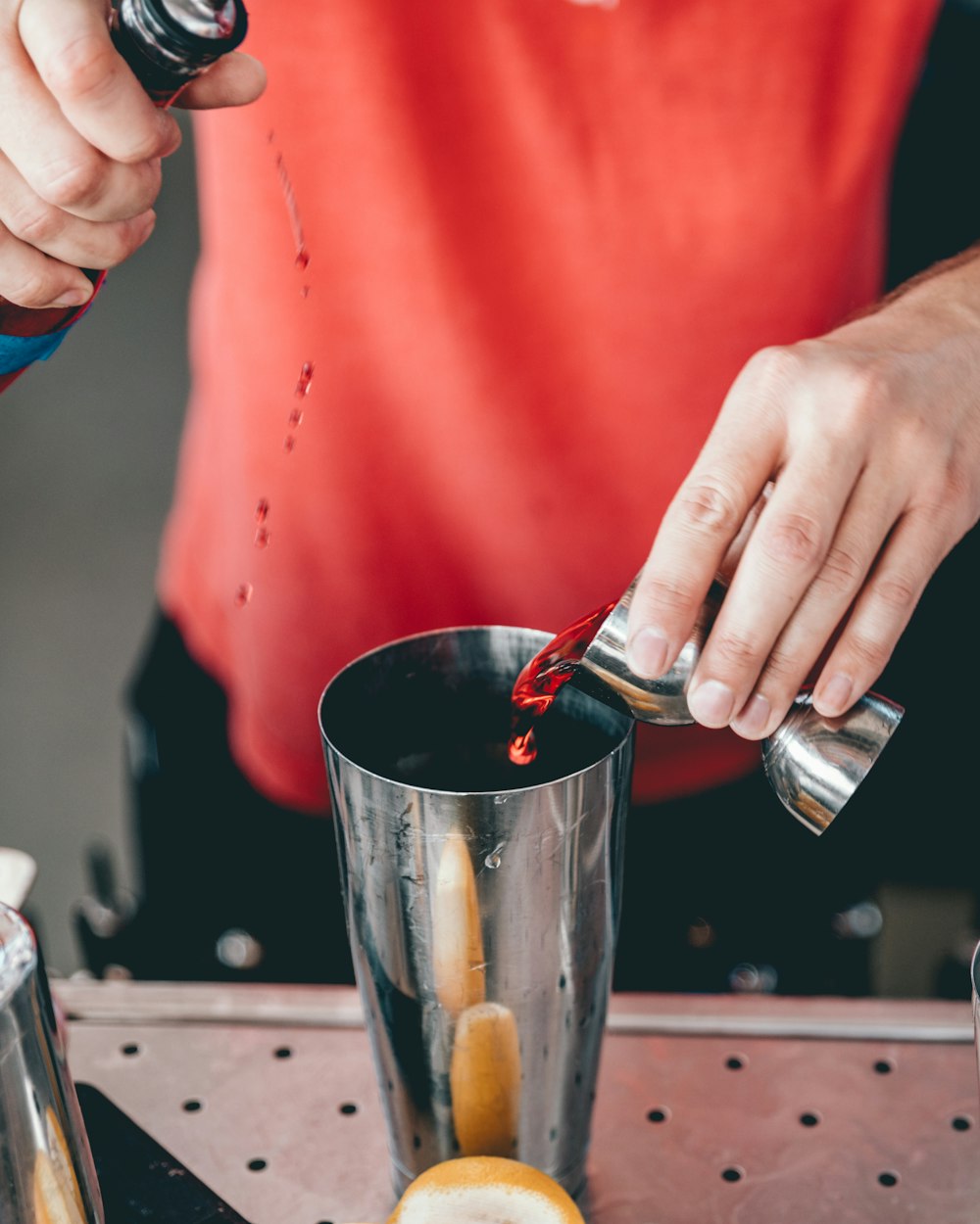 person mixing beverage on cup