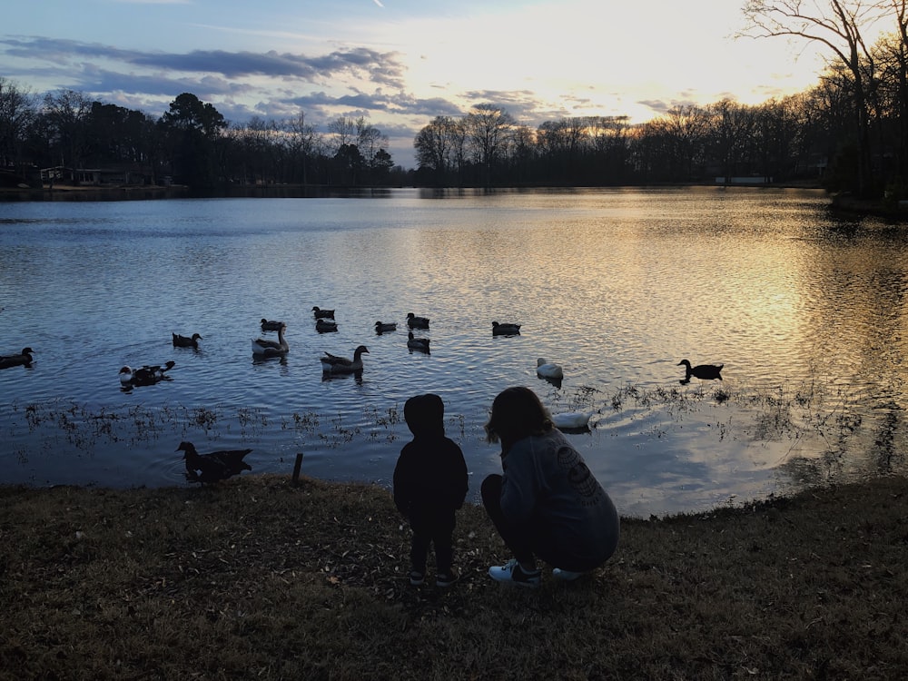 woman and child near body of water during daytime