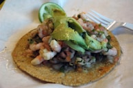 A plate of crispy tostadas topped with fresh seafood and avocado.