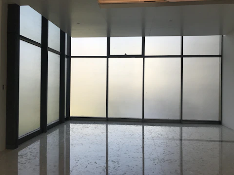 Modern office window with sleek privacy film applied, softly diffusing light.