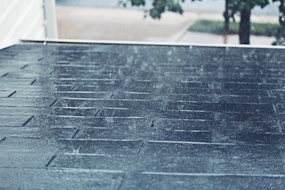 A newly completed roof gleaming after a morning rain in a quiet Maine neighborhood.