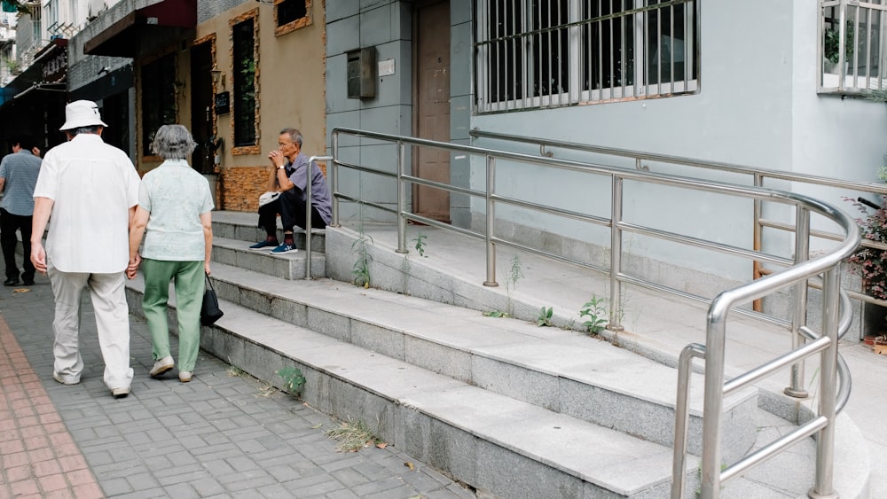 man and woman walking beside building during daytime