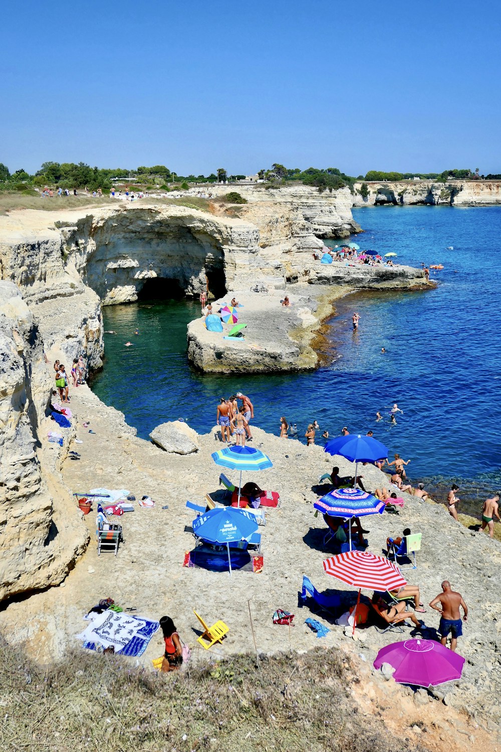 people on rocky shore during day