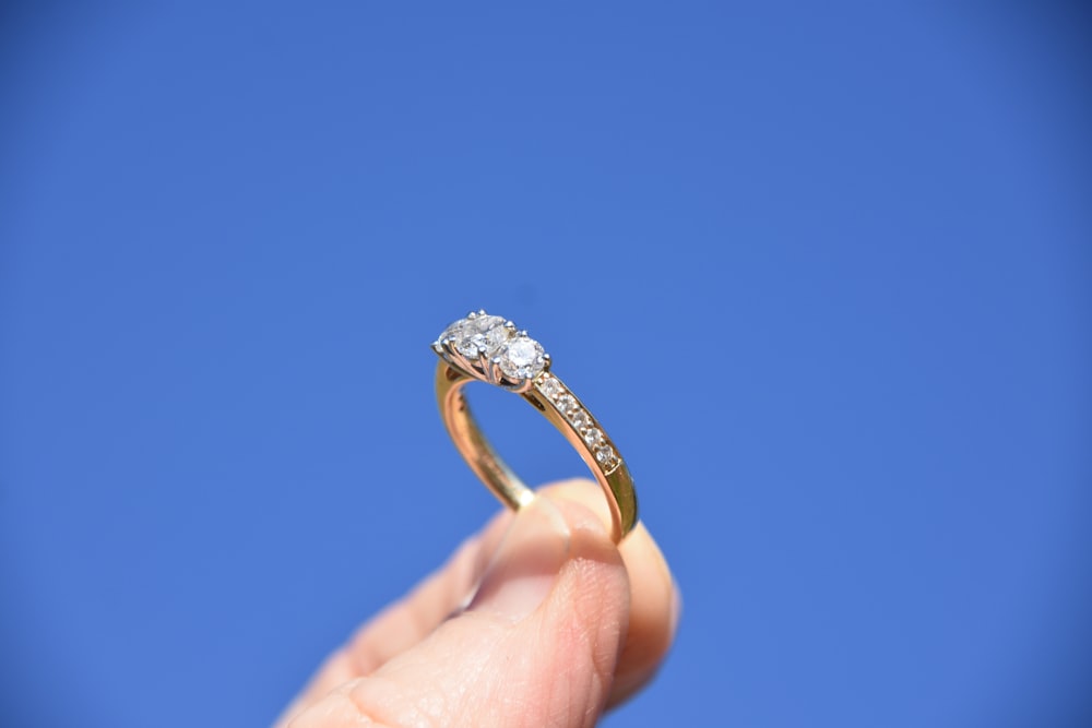 person holding gold-colored ring