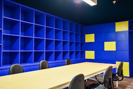 A professional consultant discussing strategy with a client in a bright office with light blue accents.