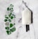 A white ice cream popsicle with a black stick lies on a marble surface next to various pieces of green and clear sea glass arranged in a gallery-like display.