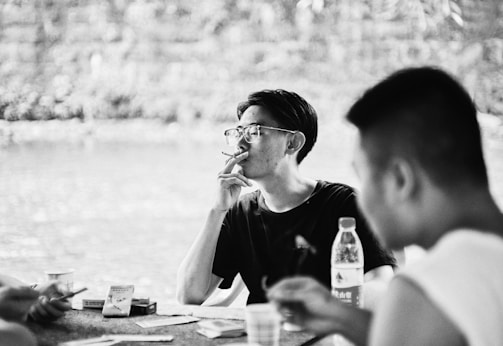 Vintage photo of friends sharing a bong outdoors.