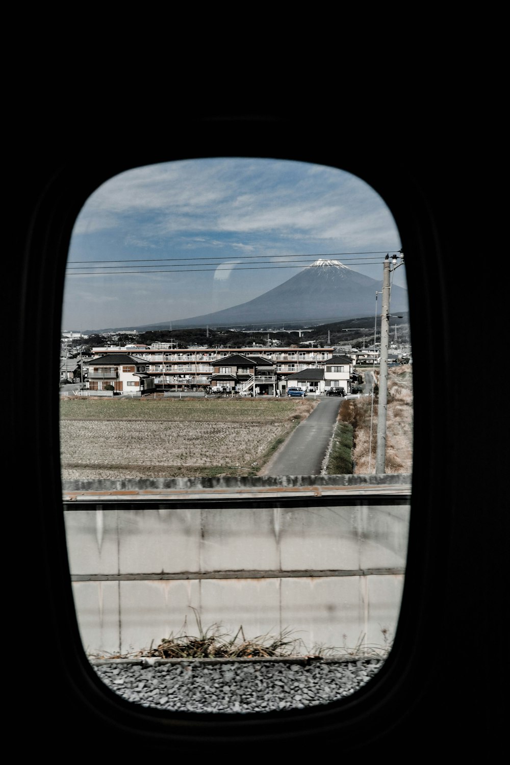 a view out of an airplane window of a road and a mountain