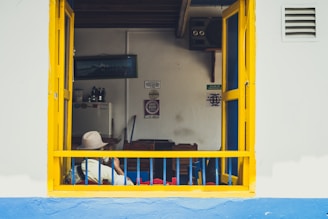 man sitting near window wearing cowboy hat