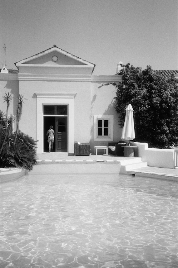 grayscale photo of concrete house near trees