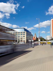 Commercial office building with glass front and busy street view.