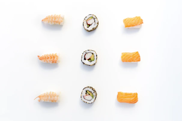 An artful arrangement of assorted sushi rolls on a minimalist wooden board.
