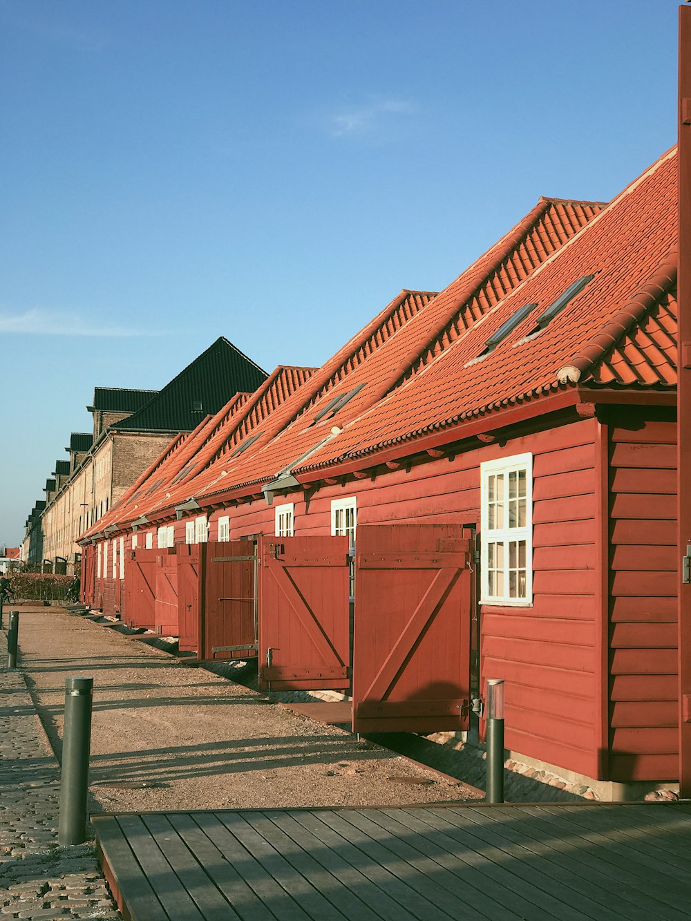 red wooden cottages under a calm blue sky