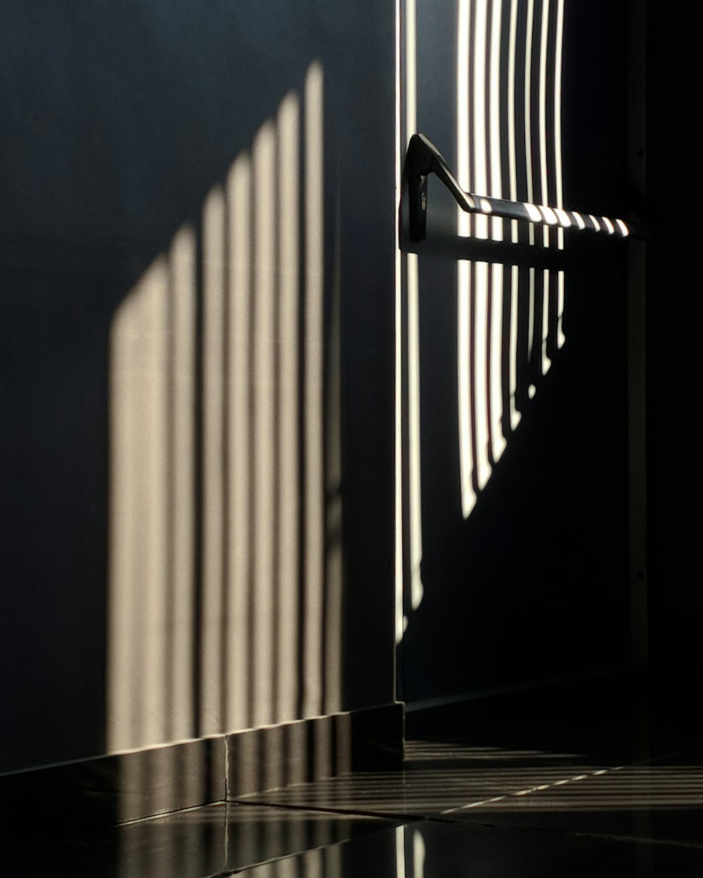 the shadow of a metal railing on a wall