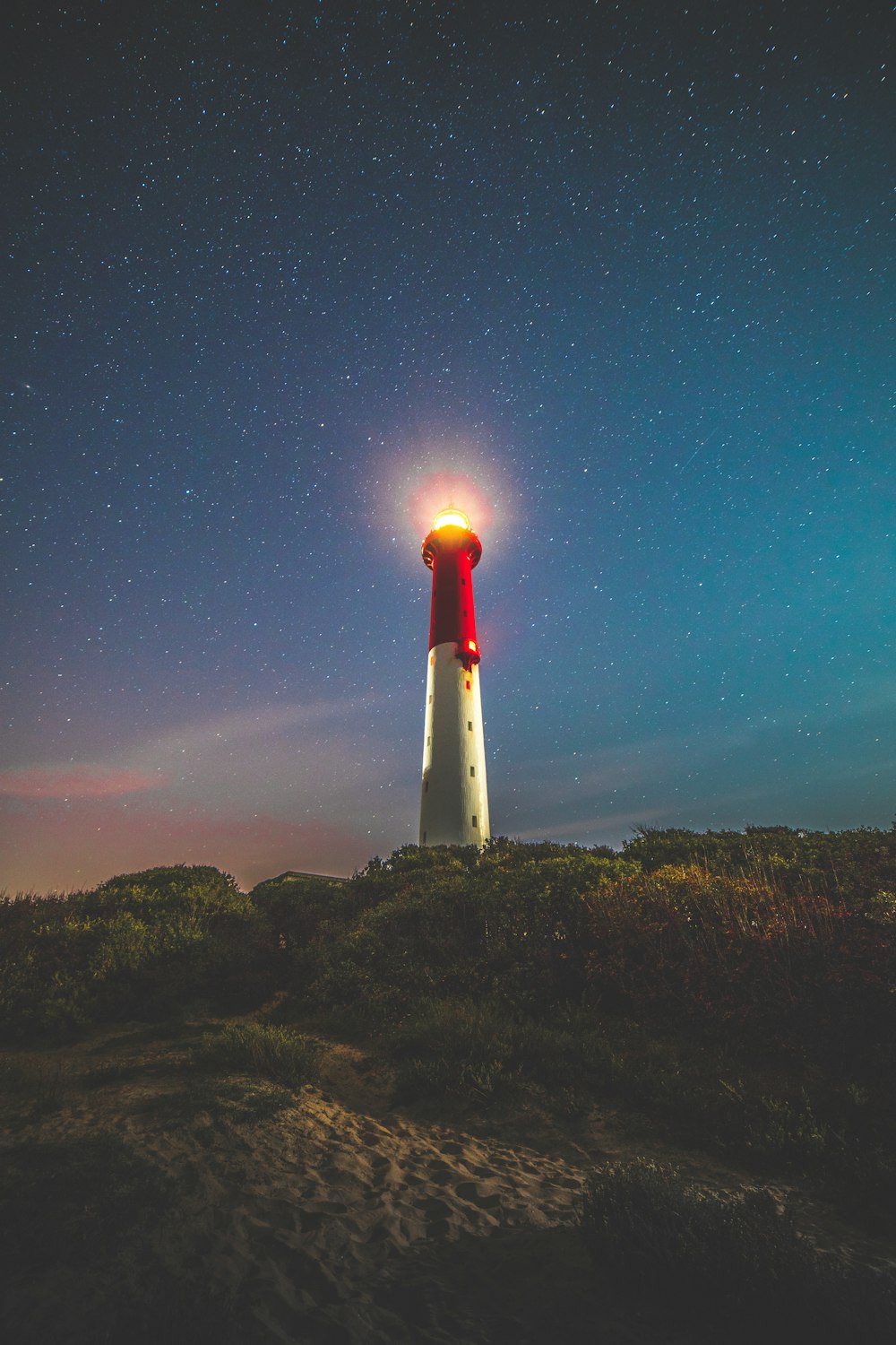 red and white lighthouse under blue sky