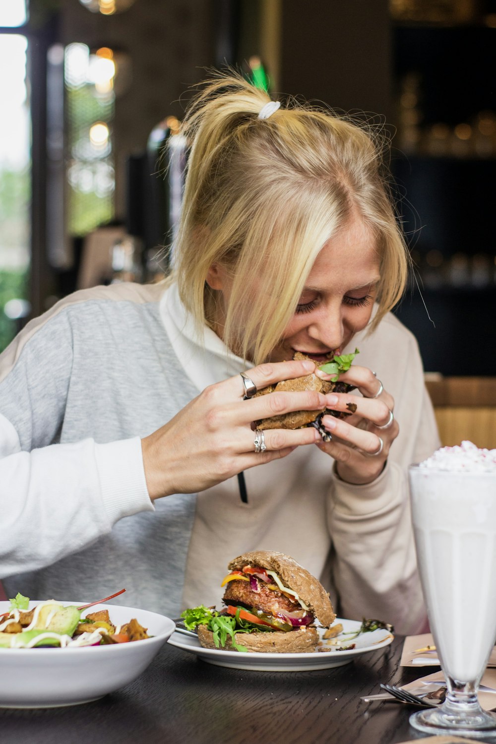 mujer comiendo hamburguesa