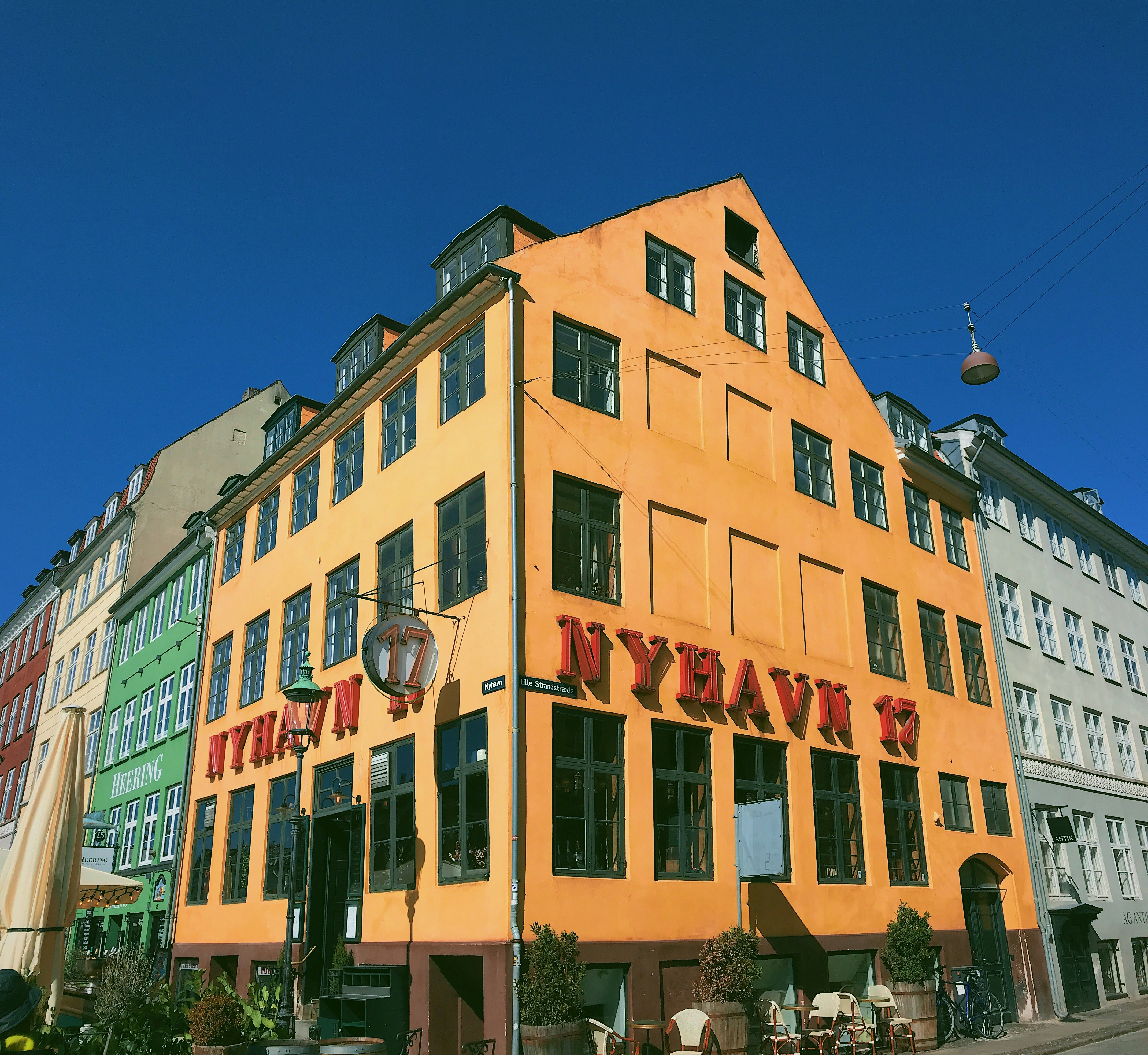 yellow and green Nyhavn 17 building under a calm blue sky during daytime