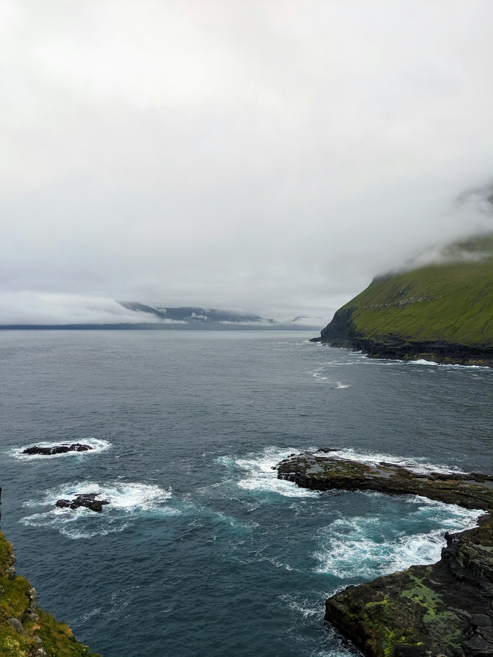 seashore rocks during cloudy day