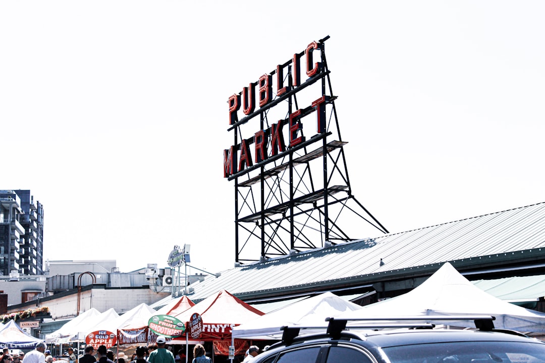 public market signage on top of building roof beside parasols during day
