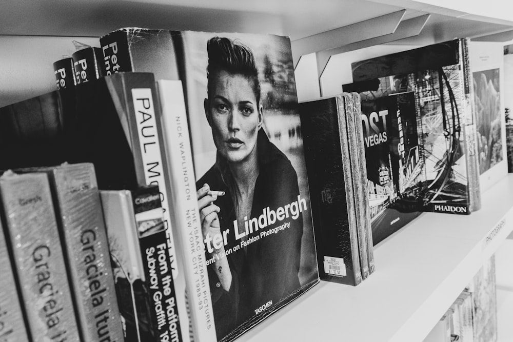 grayscale photography of assorted title book on shelf