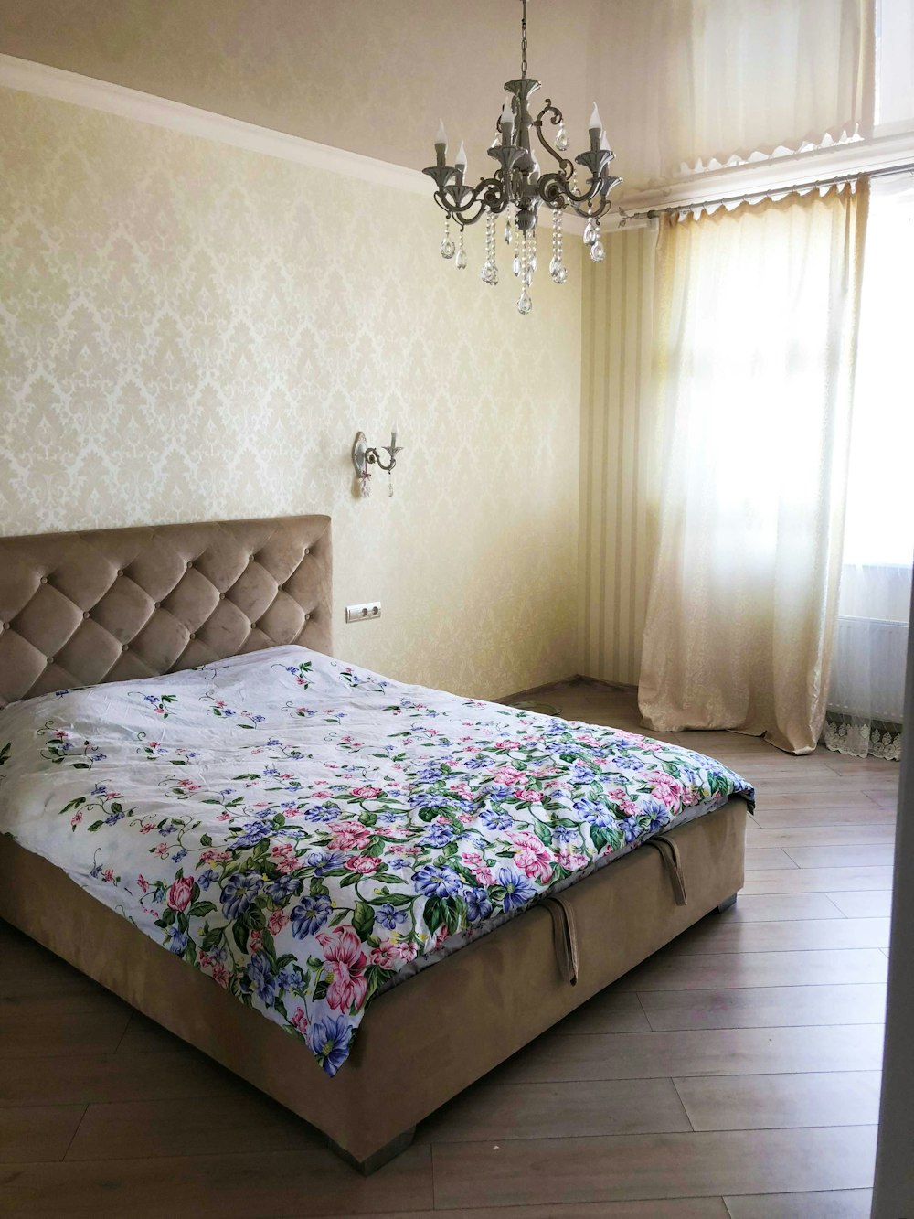 tufted bed with floral blanket