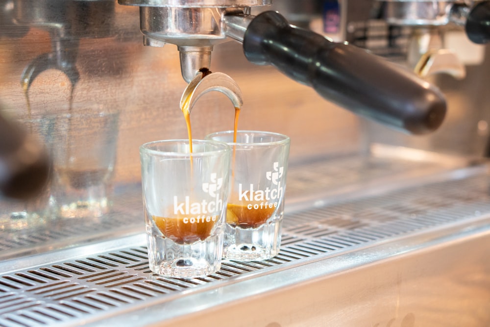 two glass with liquid being poured