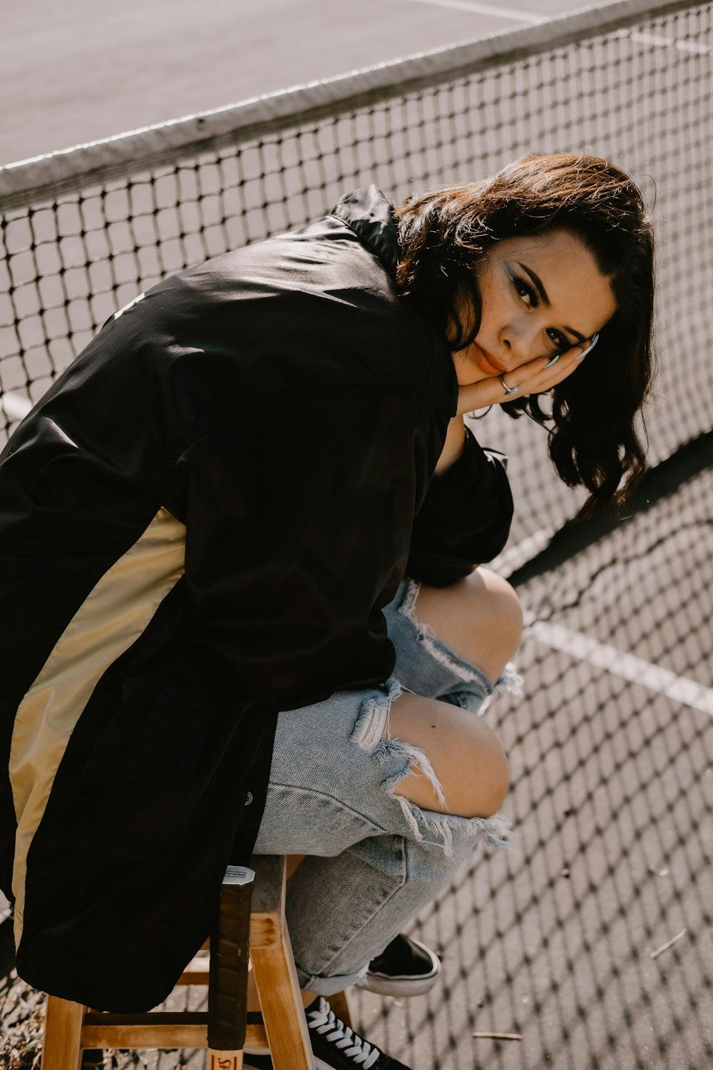 woman sitting on chair beside tennis net