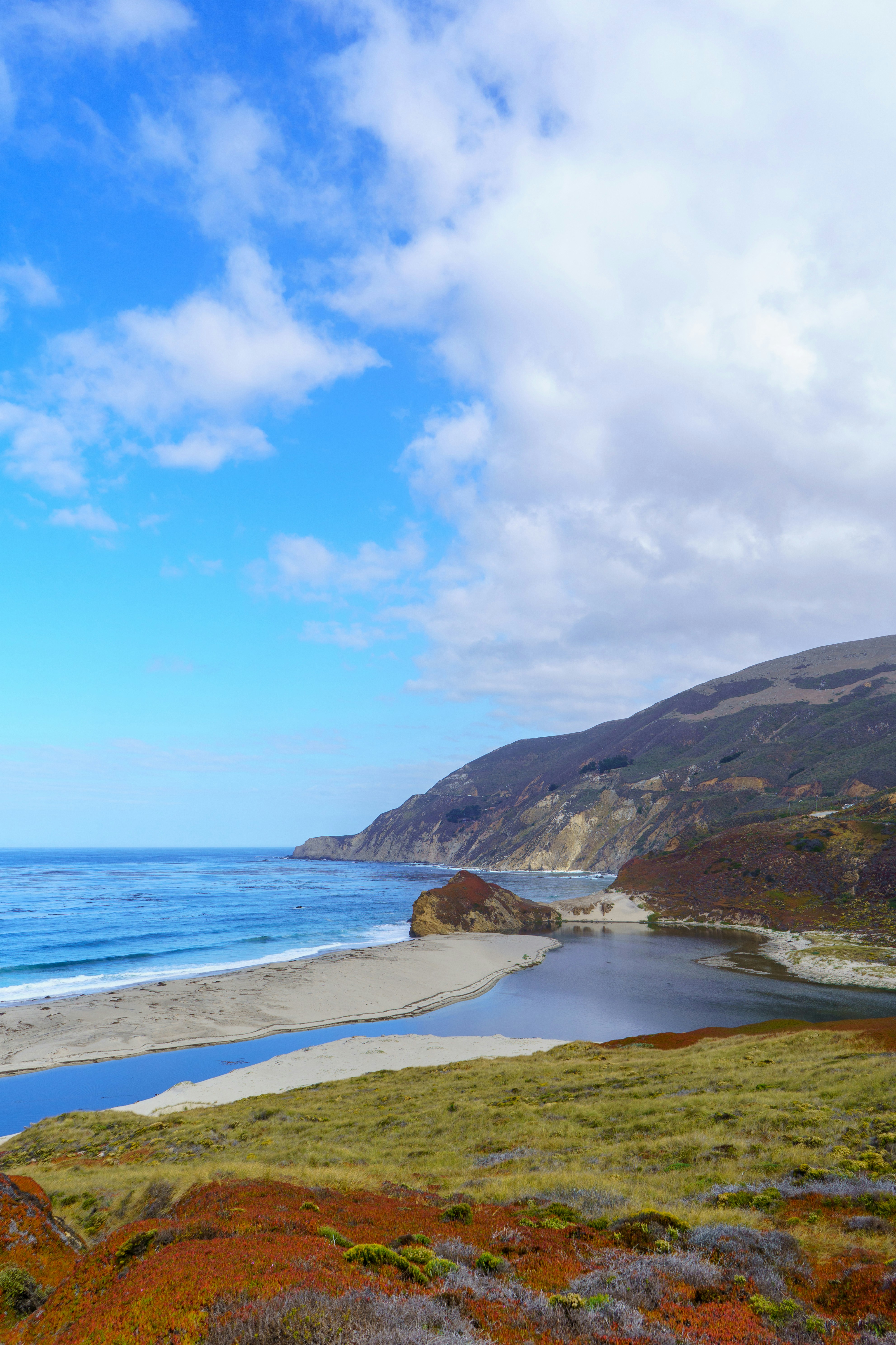 A body of water surrounded by a lush green hillside photo Free Blue