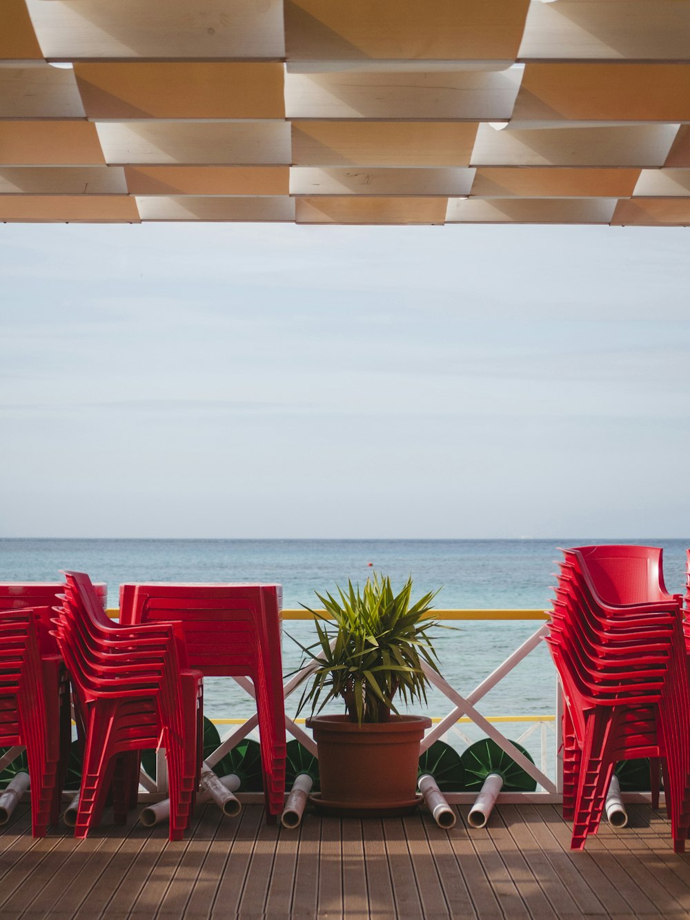 stack of red chairs and tables facing cean