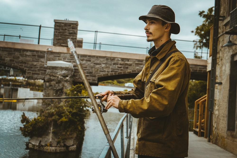 a man standing on a bridge next to a river