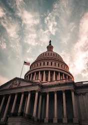 the dome of the u s capitol building under a cloudy sky