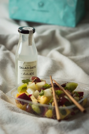 A lifestyle shot showcasing a bottle of smoked balsamic vinegar beside a gourmet salad.