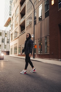 A model confidently walking down a city street wearing a sleek, modern hoodie from homer pulse wear